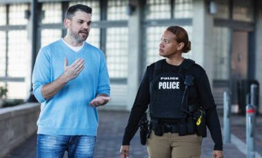 police officer and man walking inside building